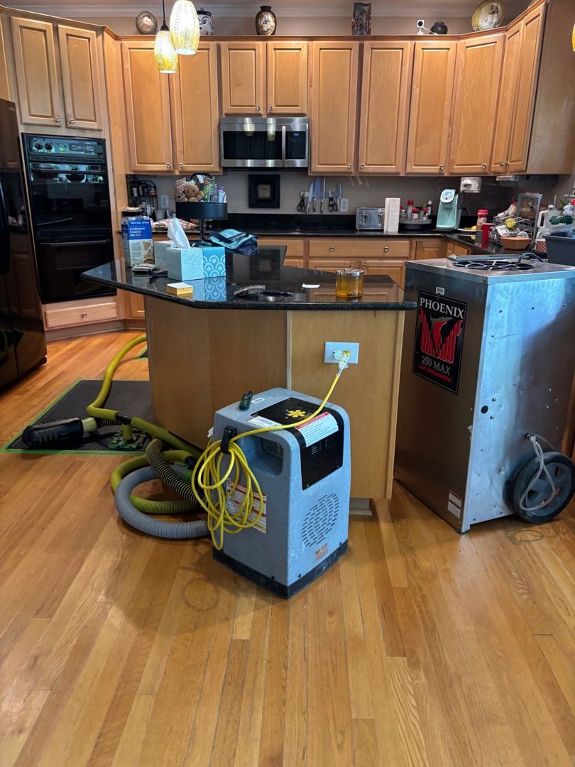 Specialty hardwood floor drying mats installed on water-damaged hardwood flooring in a Fuquay-Varina, NC kitchen.
