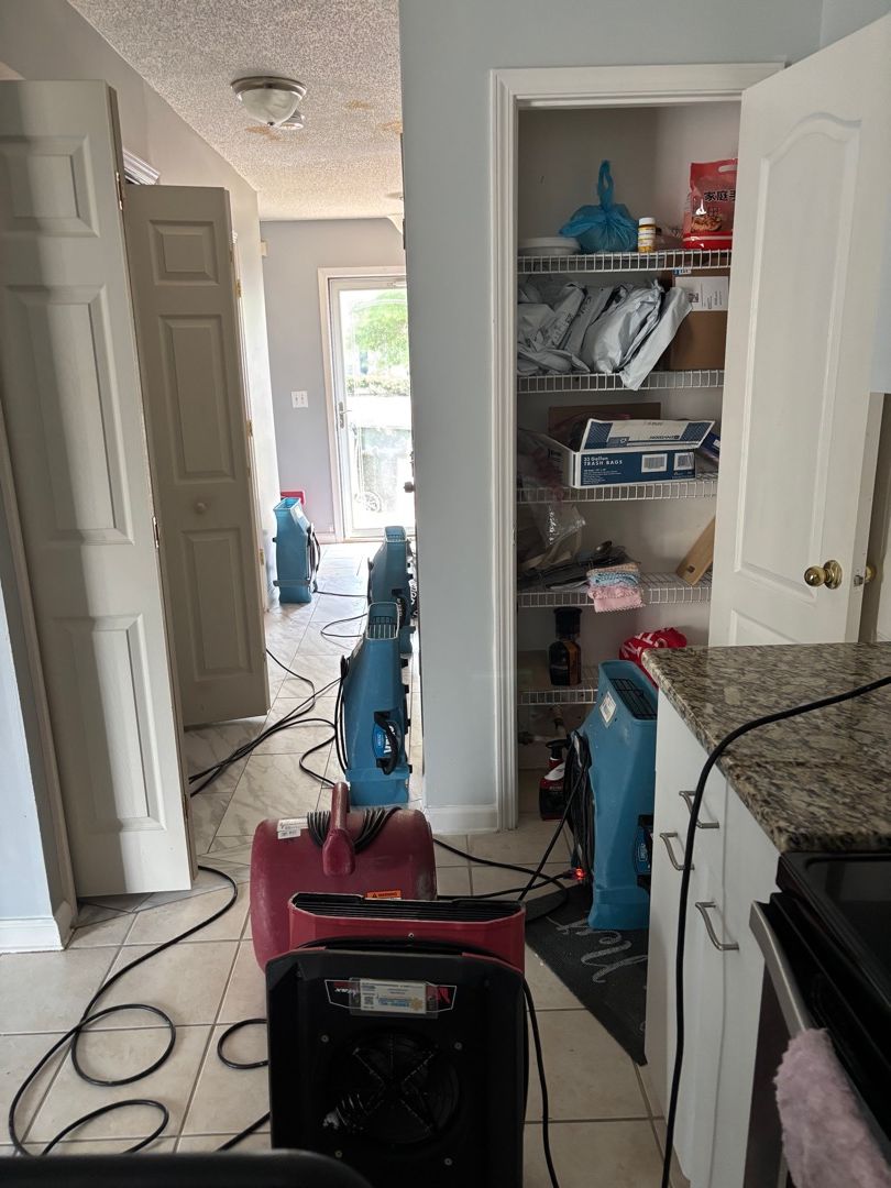 Commercial dehumidifier and air movers drying the kitchen after a multi-level water damage loss in Raleigh NC