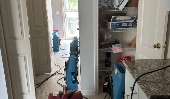 Commercial dehumidifier and air movers drying the kitchen after a multi-level water damage loss in Raleigh NC