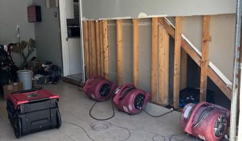 Air movers drying wall cavities after flood cuts in Raleigh NC garage water damage restoration project